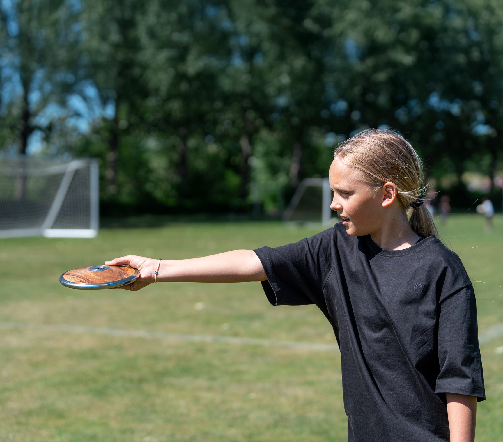 fem børn løber på rød atletik løbebane