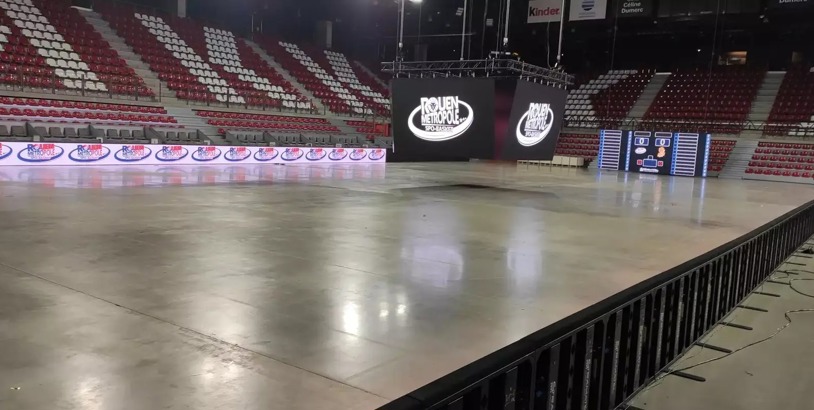 Stora LED-skärmar och digital resultattavla framför läktaren i en inomhusarena