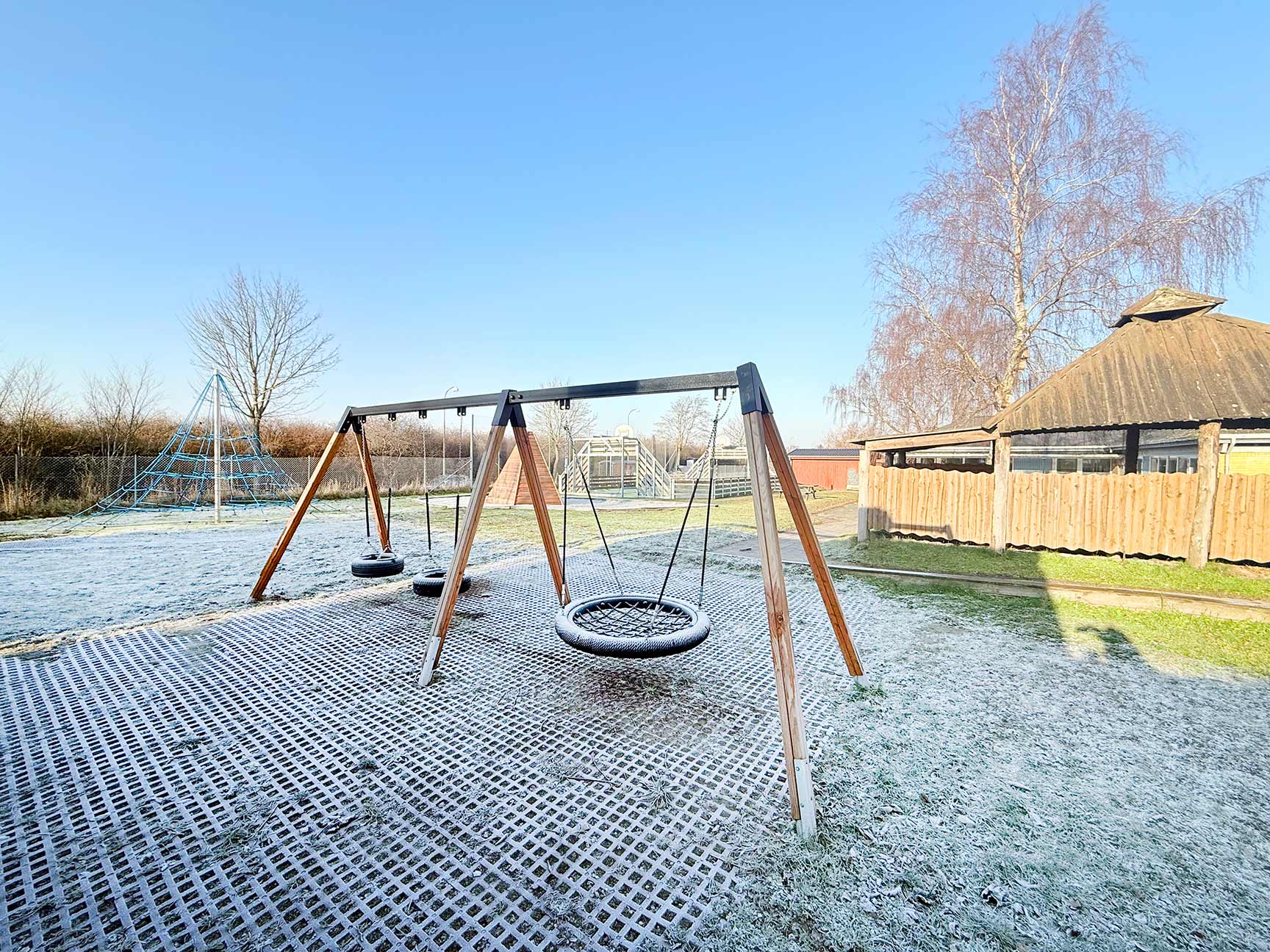 Legeplads med gyngestativ, bålhytte, klatrepyramide, legehus og multibane