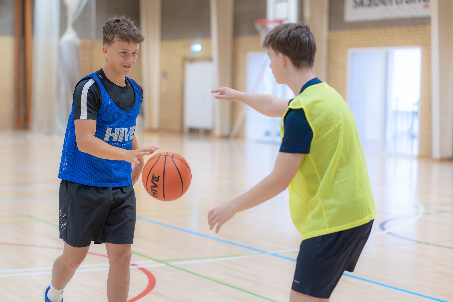 Drenge der spiller basketball i skolens idrætshal
