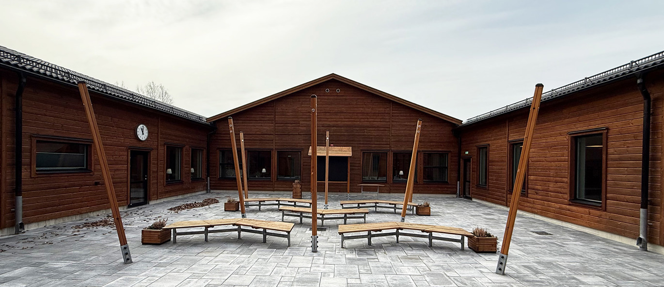 Uteklassrummet Pennskrinet med bänkar i rader och en svart tavla på Älghultskolans stenlagda innergård i Uppvidinge kommun.