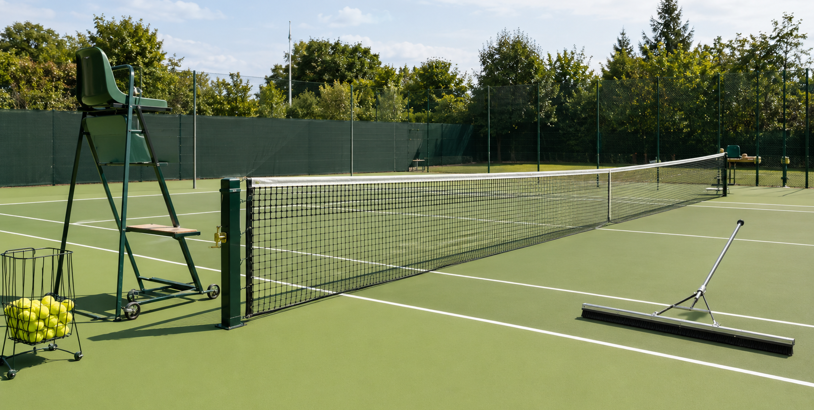 Utrustning till tennisbana med nät, domarstol, bollkorg och redskap för banskötsel.