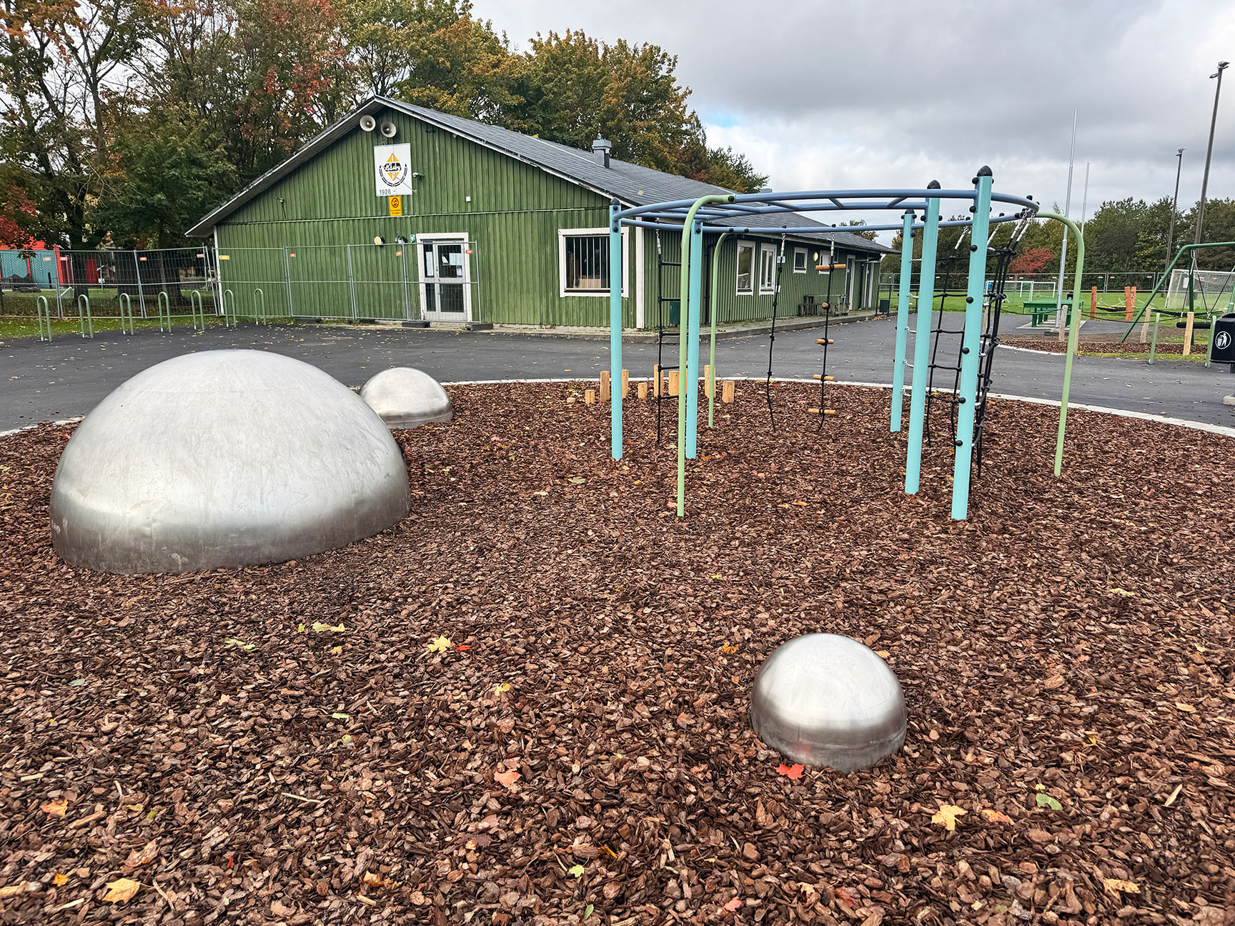 Lekplats på Näsby IP i Kristianstad med klätterställning, balanskulor och kupolformade balanselement i anslutning till idrottsplats.