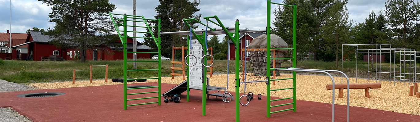 Utegym och aktivitetsyta i bostadsrättsförening med träningsredskap, klätterställningar och fallskyddsyta.