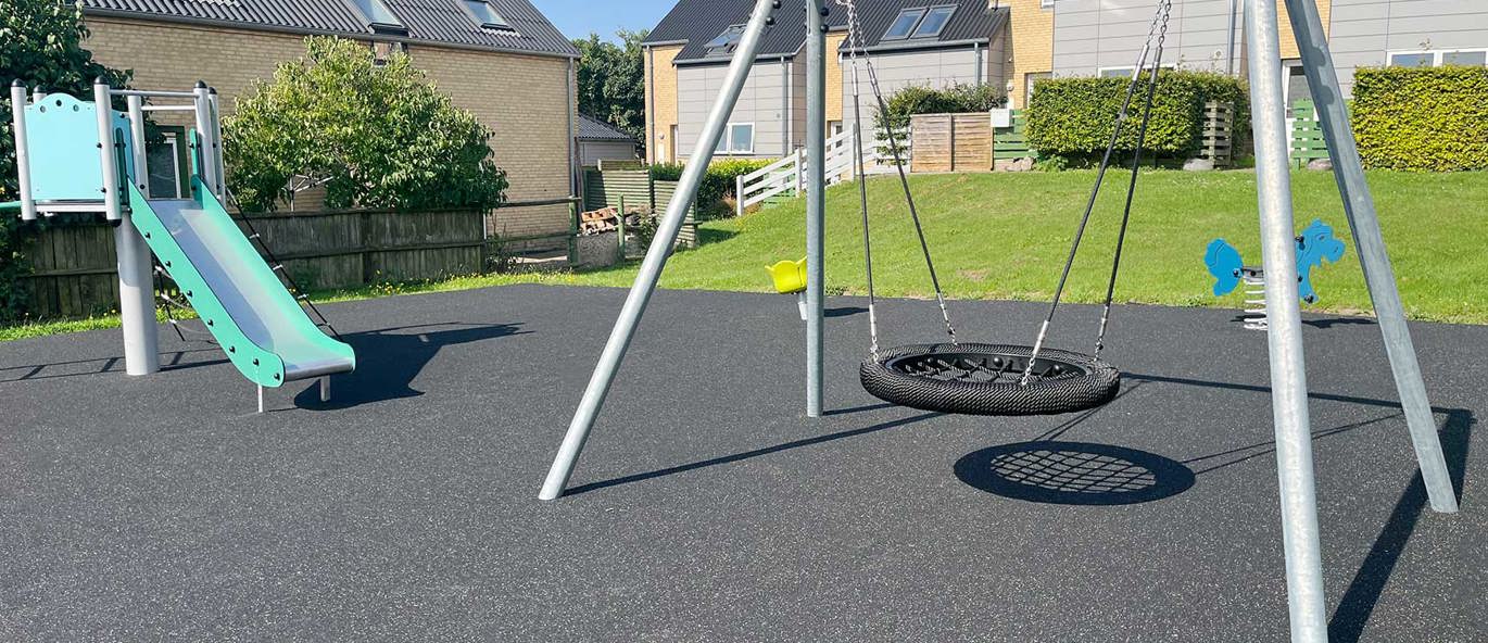 Lekeplass med huskestativ, rutsjebane og vippedyr.