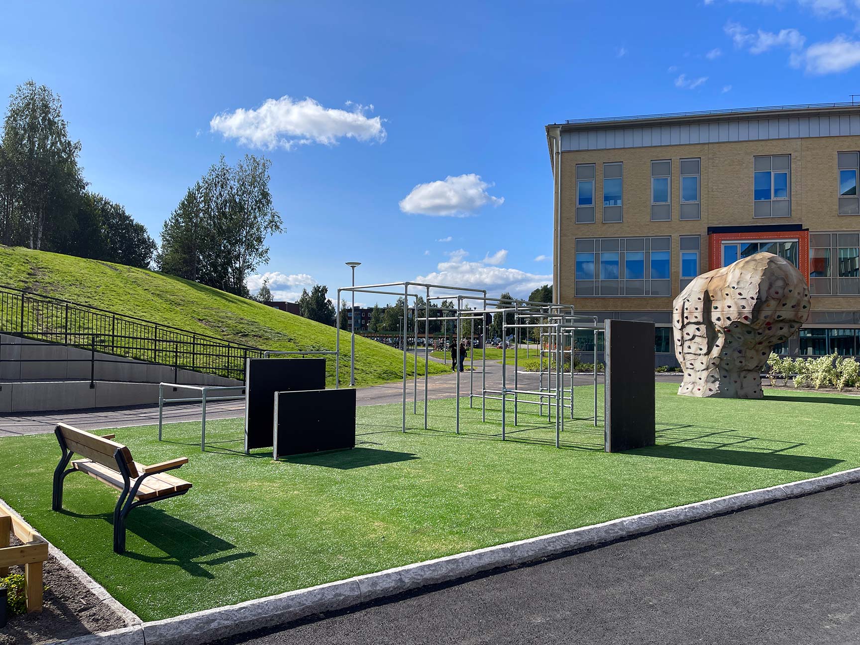 udendørs aktivitetsområde med træningsstativer og bænke
