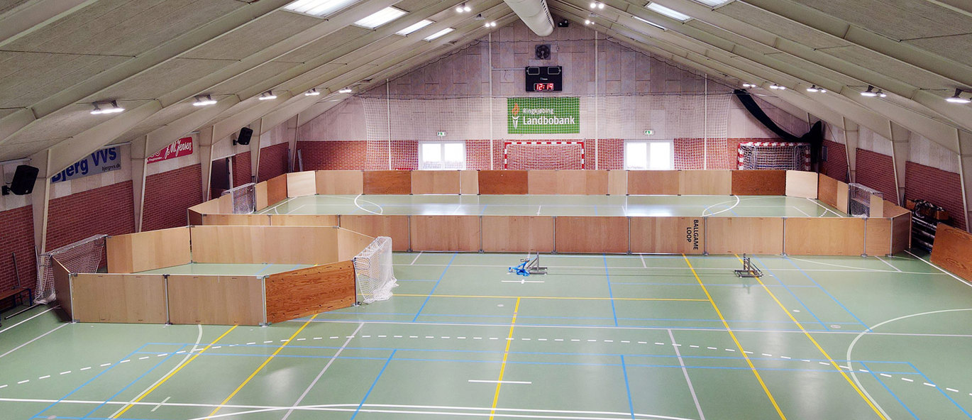 Idrettshall i Tarm, Danmark, med fleksibel sargløsning, grønt sportsgulv med linjemarkeringer og mål for flere ulike idretter.