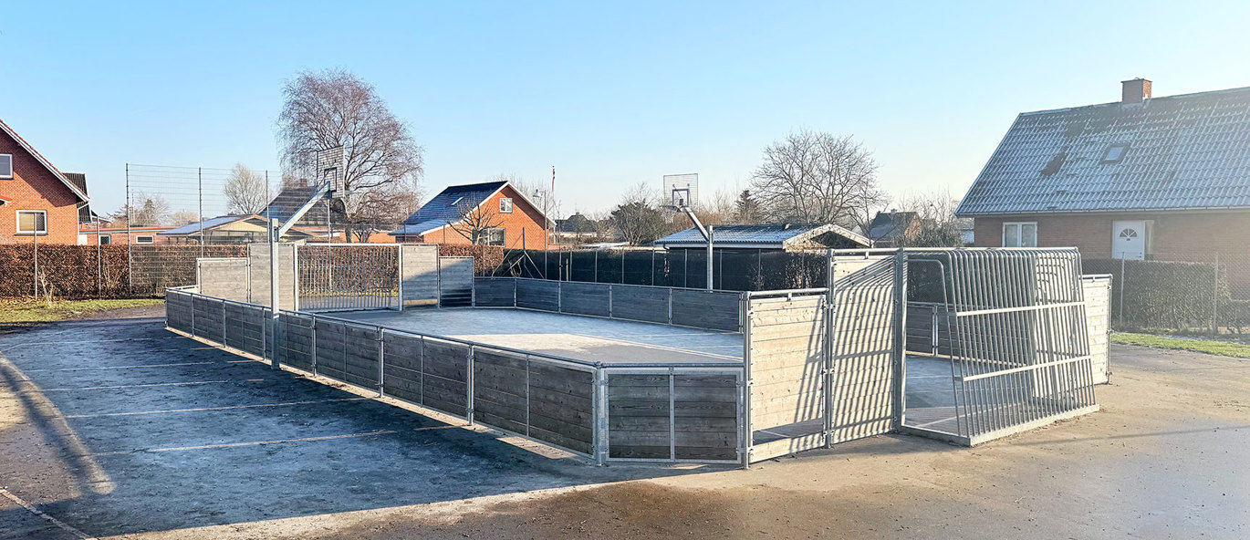Skolegård med multibane, vant i lerketre og basketballstativer