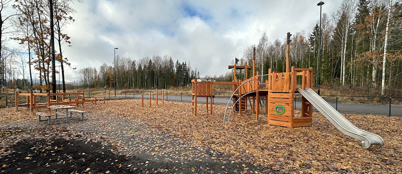 Lekplats med klätterställning och balansbana i naturmaterial.