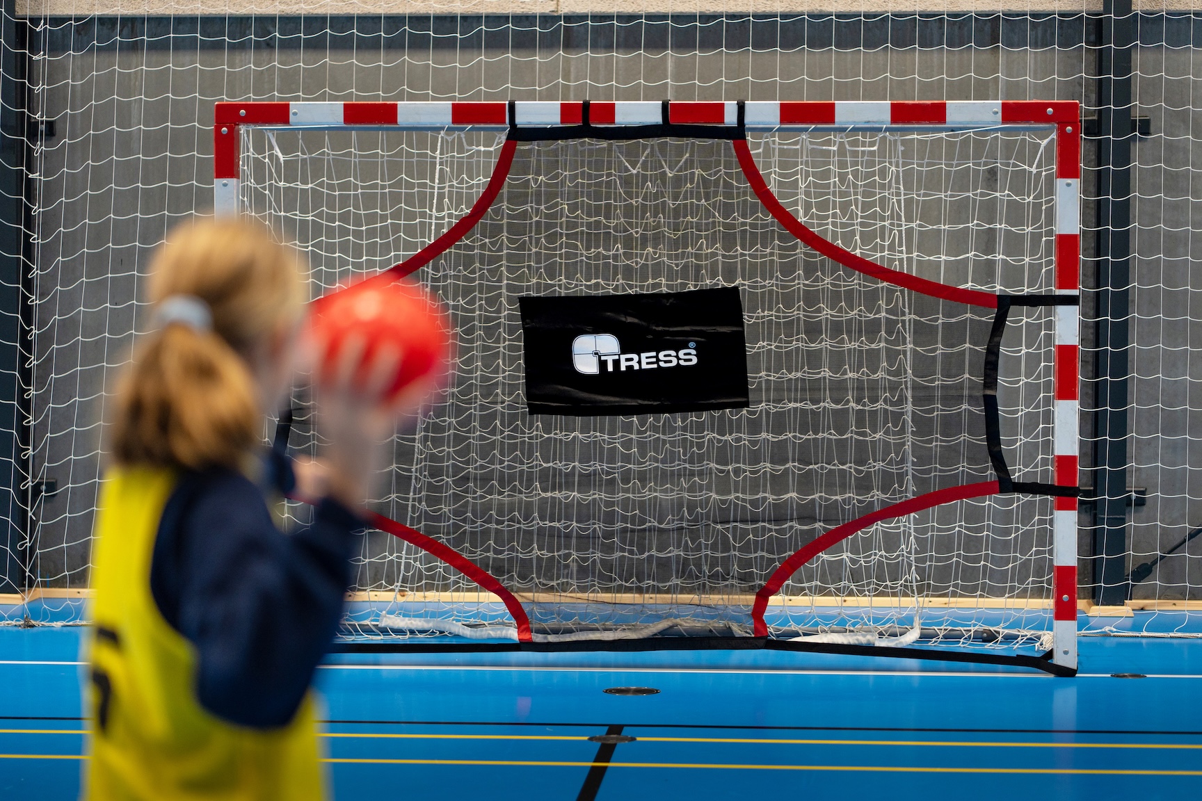 pige skyder på mål mod et håndboldmål med skudtræningsdug