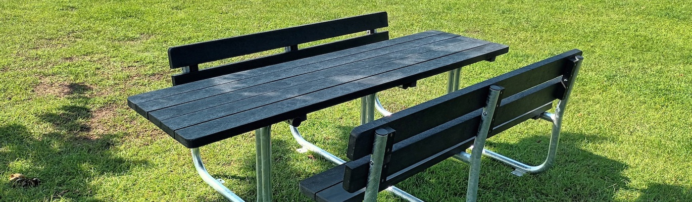 Rullestolvennlig benkbord i parkområde rett ved havet