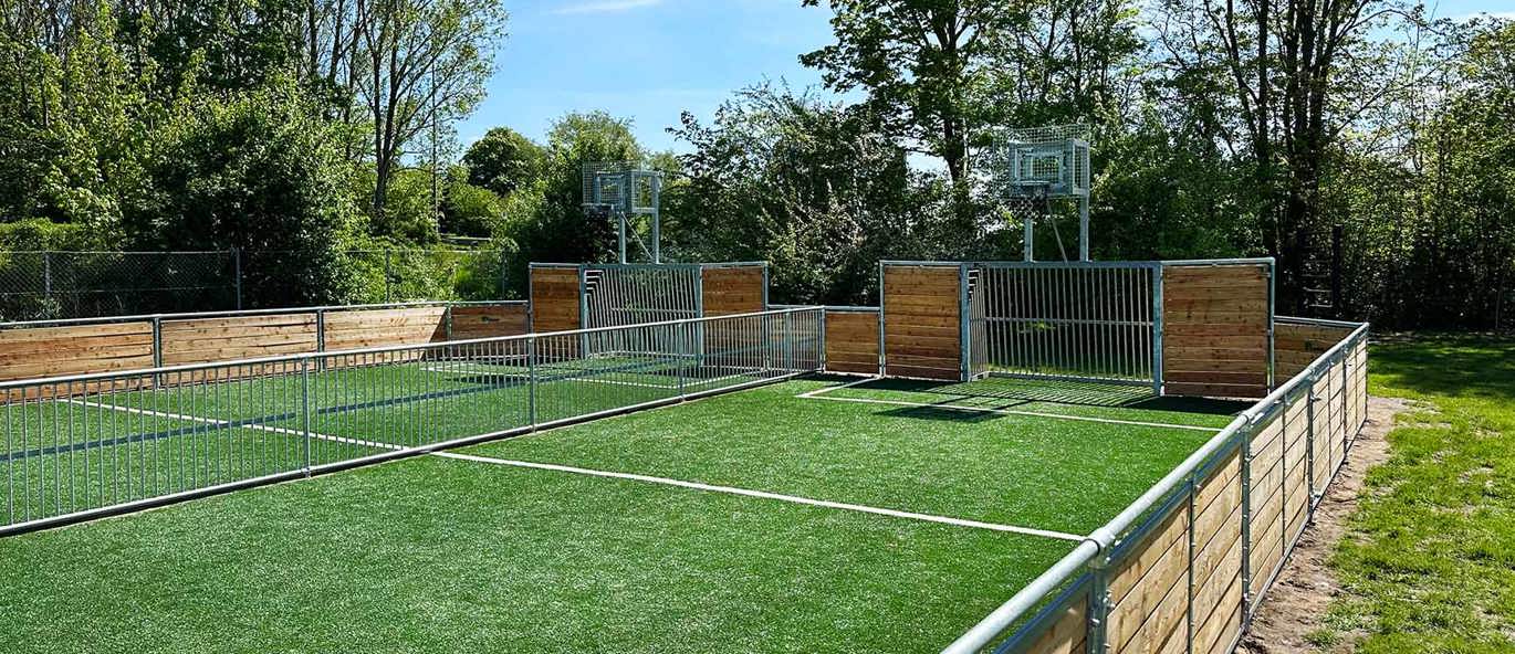dobbelt multibane i træ med kunstgræs, fodboldmål og basketballstativer