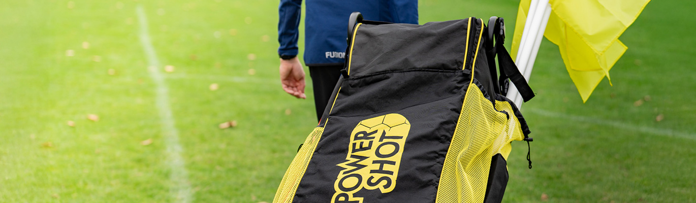 Träningsutrustning för fotboll på plan med väska och koner inför träning