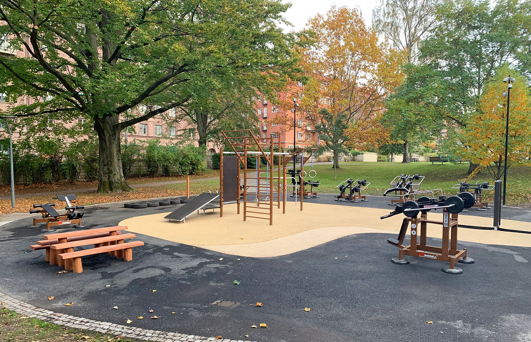 Udendørs fitnessområde med træningsstativ og styrketræningsmaskiner
