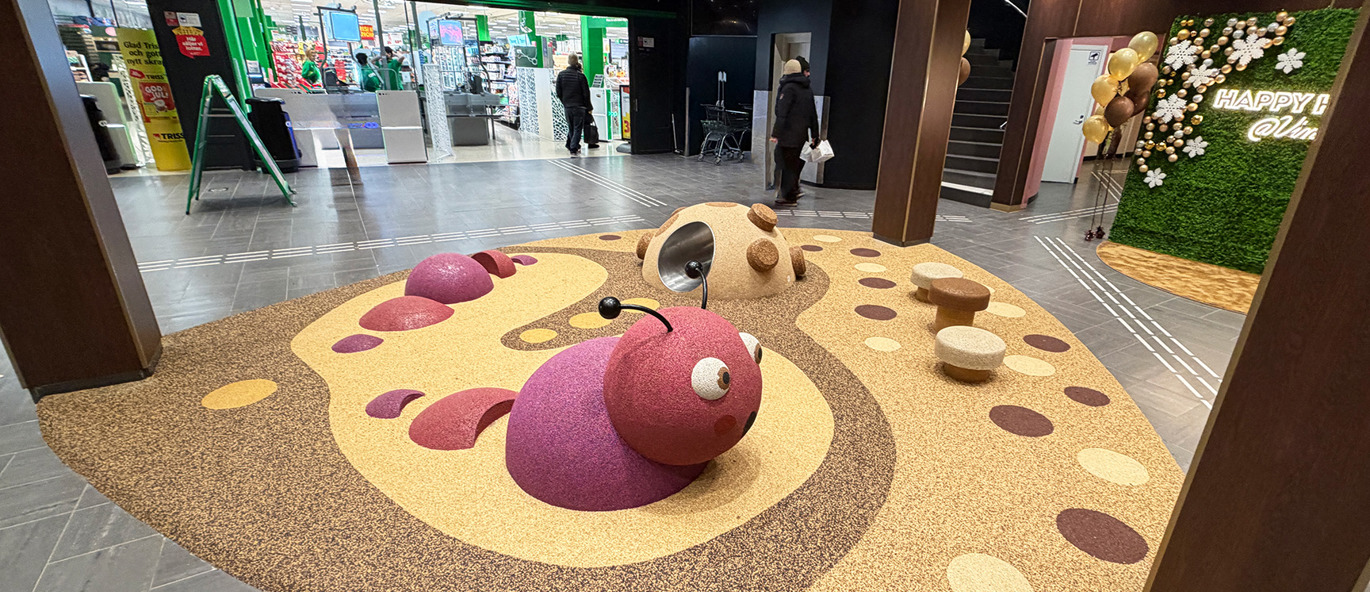 Ett torg inne på ett köpcentrum, lekplats med gummifigurer med rymdtema.