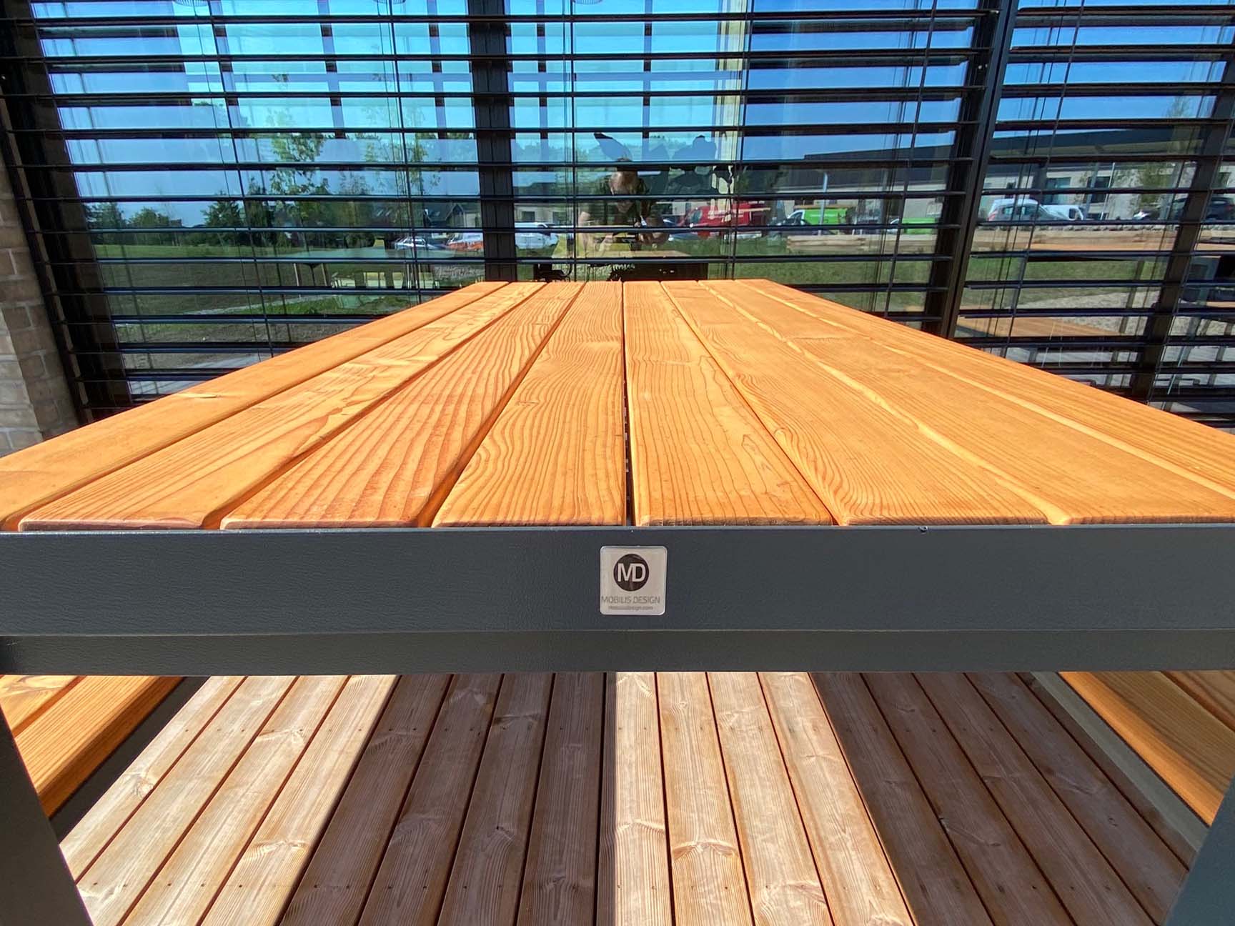 billede af træbord med stålkant og med mærkat Mobilis Design med vinduer i baggrunden