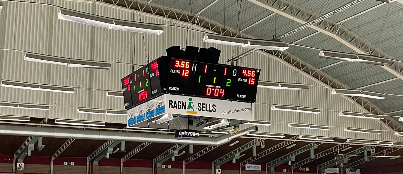 Centralt hängande resultattavla i HIVE Arena i Boden med matchtid och resultat, ovanför läktarsektionerna i ishallen.
